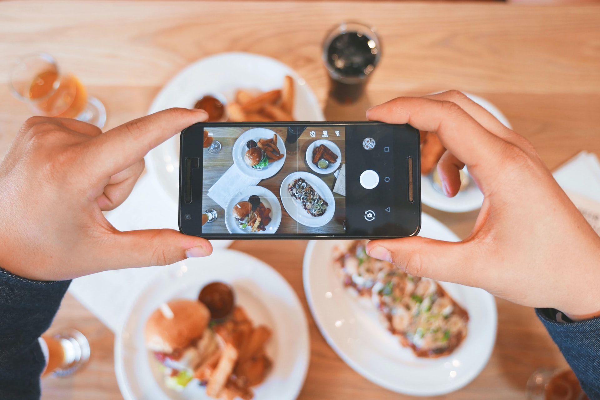 A person taking a picture of food using their smartphone