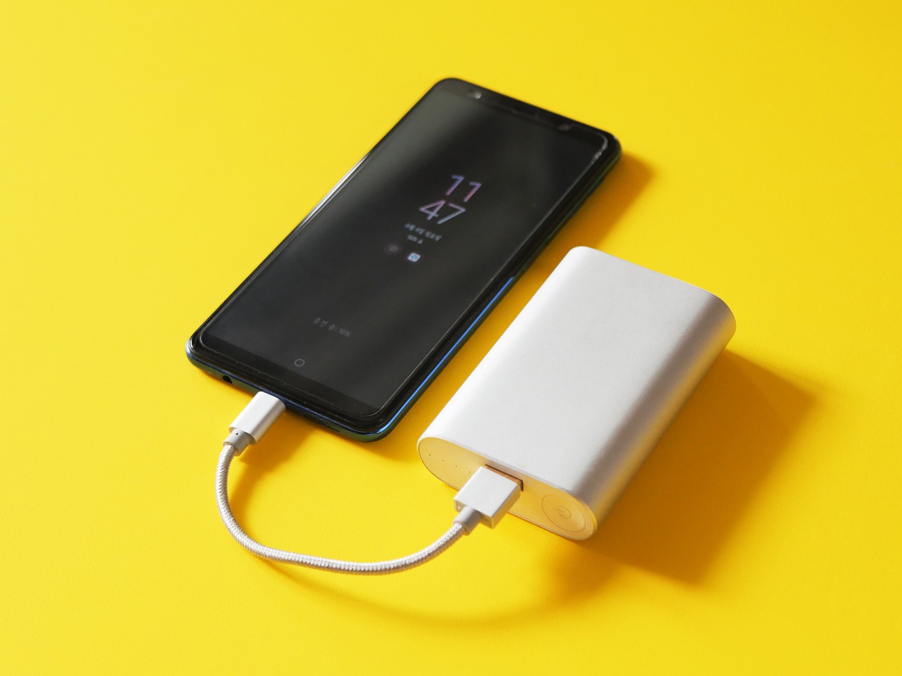 A power bank charging a smartphone